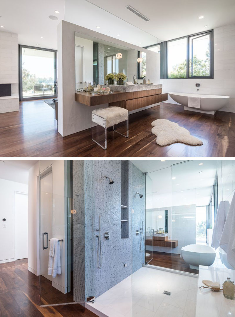 This master bathroom with dual showers and standalone bathtub, is tucked away behind a partition wall behind the bed.