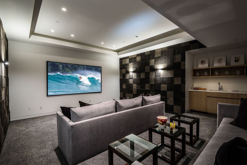 This theater room has tiered seating and a small bar.