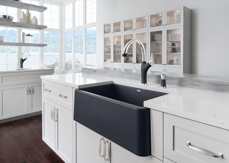 This black farmhouse sink is in direct contrast to the counter and cabinets, making it a bold statement piece.