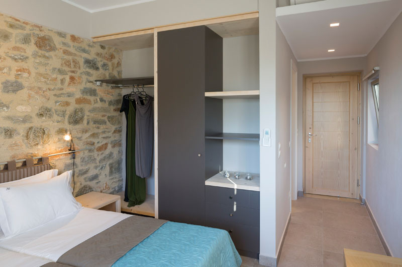 This bedroom in a Greek villa has a partially exposed wardrobe.