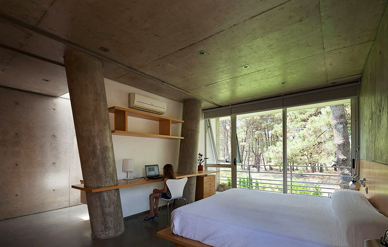 A wood desk and shelving was built in an awkward space between two angled concrete columns.