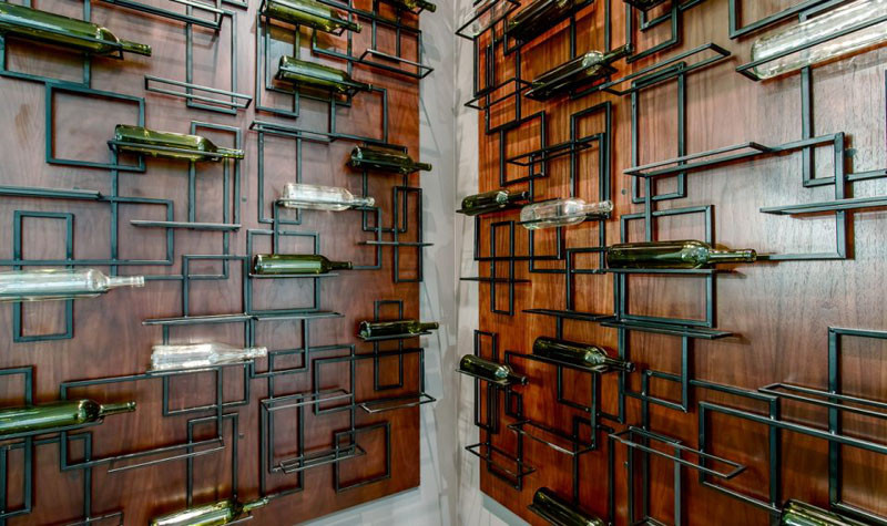 This wine cellar has artistically designed metal bottle shelves.