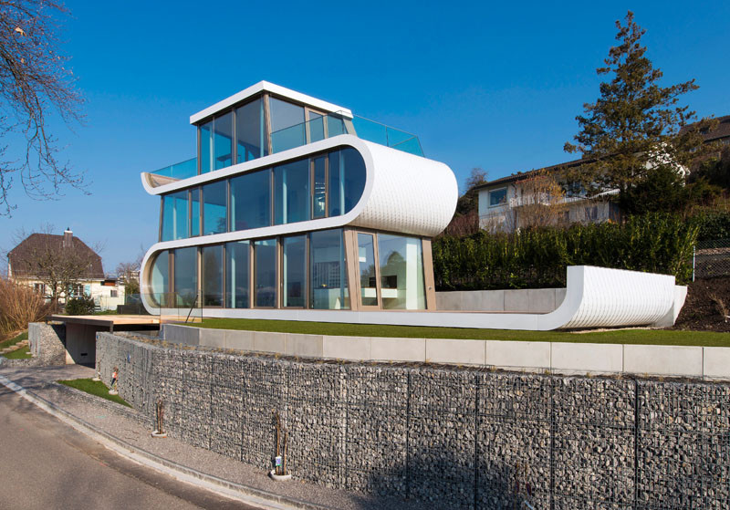 This family home on Lake Zurich, Switzerland, seems almost ribbon-like in its design, with the white facade folding its way through the home, easily defining the various floors.