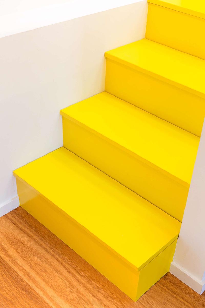These Bright Yellow Stairs Include Hidden Spaces For Storage