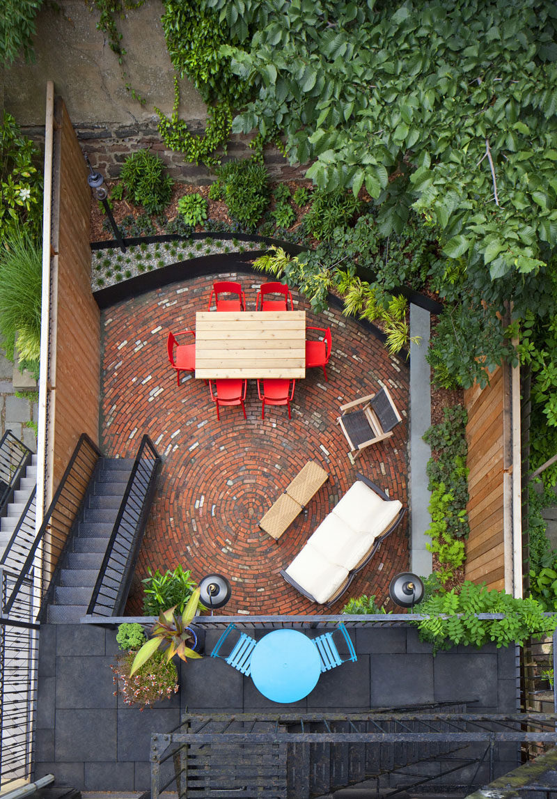 16 Inspirational Backyard Landscape Designs As Seen From Above // The bright colors of the furniture and the circular brick pattern on this back patio in New York, mix with the surrounding greenery and make for a fun space. #Backyard #YardIdeas #LandscapingIdeas #YardLayout #YardDesign