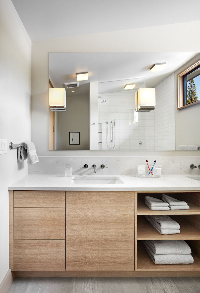 15 Examples of Bathroom Vanities That Have Open Shelving // The combination of drawers, a cabinet, and open shelving, make for a variety of bathroom storage options in this wooden vanity.