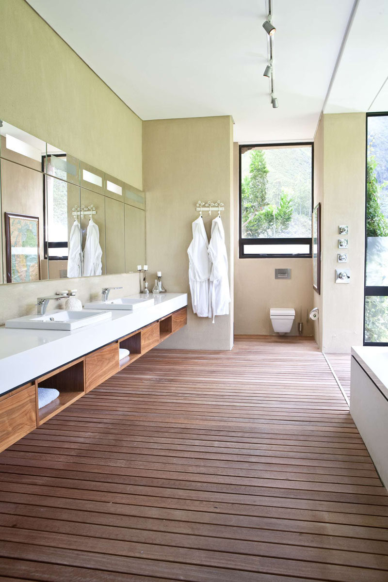 15 Examples of Bathroom Vanities That Have Open Shelving // This spa style bathroom has wood shelves built into the vanity, in keeping with the natural feel of the rest of the space.