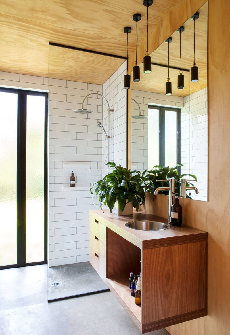 15 Examples of Bathroom Vanities That Have Open Shelving // The vanity in this bathroom contains drawers and a wide open compartment for additional storage.