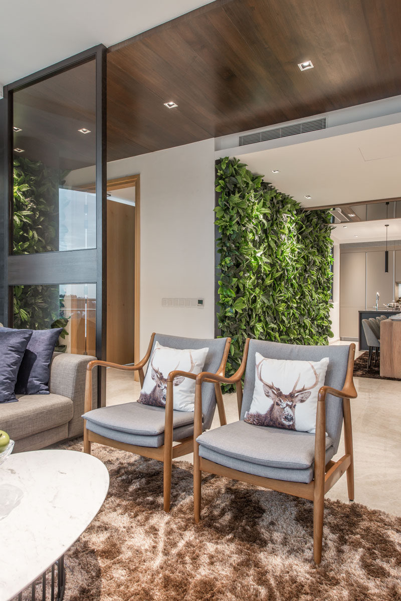 This apartment has a wood feature ceiling and a green wall next to the dining area.