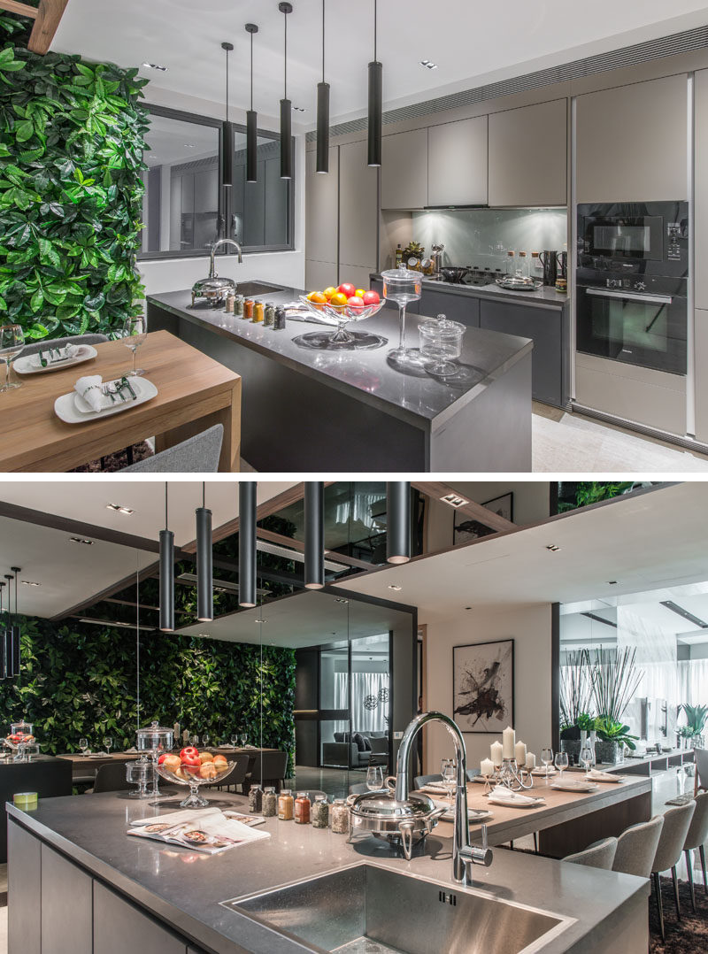 This kitchen is full of grey cabinets with matching countertops, and 5 individual pendant lamps light up the kitchen island.