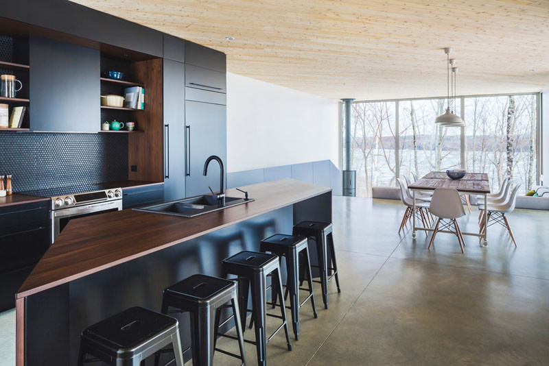 This kitchen has a dramatic color palette of black and deep rich wood.