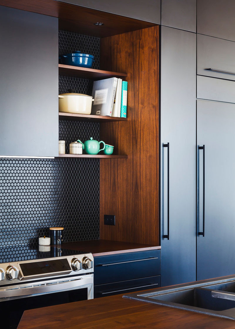 Small black hexagon tiles contrast the deep rich wood countertop and shelves.