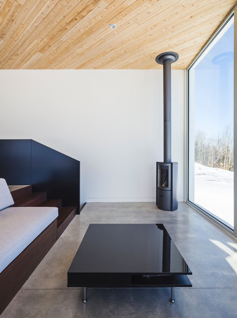 In the corner of this living room, a small cylindrical fireplace has been added, and a low profile coffee table makes sure the view remains unobstructed.