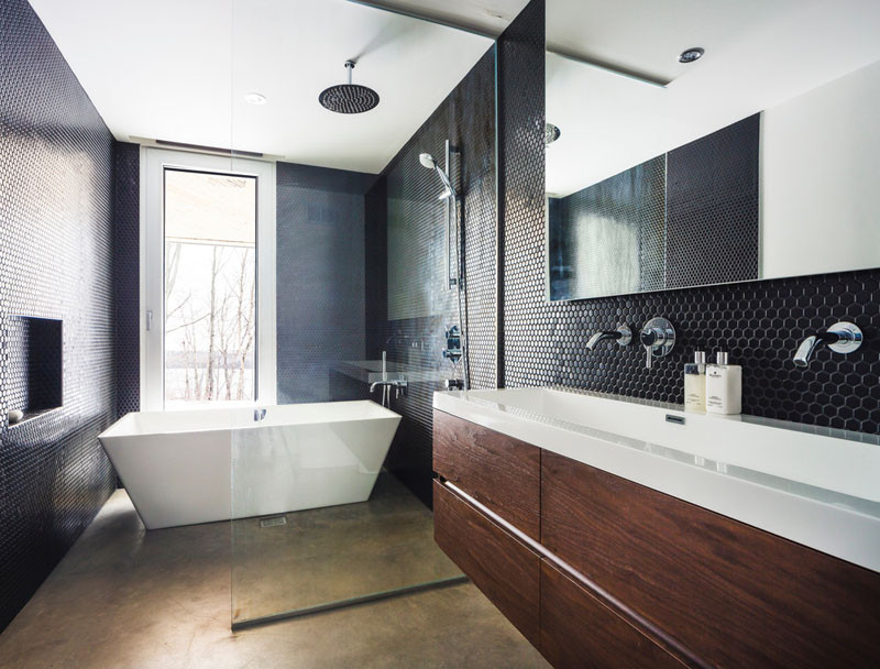 In this bathroom, black tiles create a dramatic touch, and the bath is positioned to take advantage of the view.