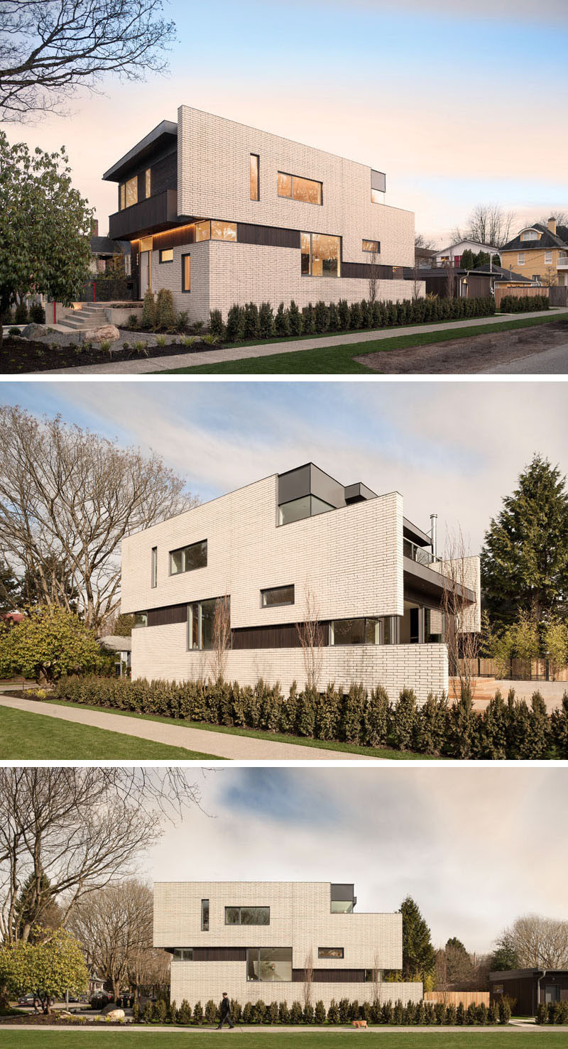 This contemporary home, with a facade of white brick, is located on a corner lot in a quiet neighborhood of Vancouver, Canada. The home, designed by architect Randy Bens, also has dark stained cedar siding running vertically and horizontally, and zinc colored metal trim.