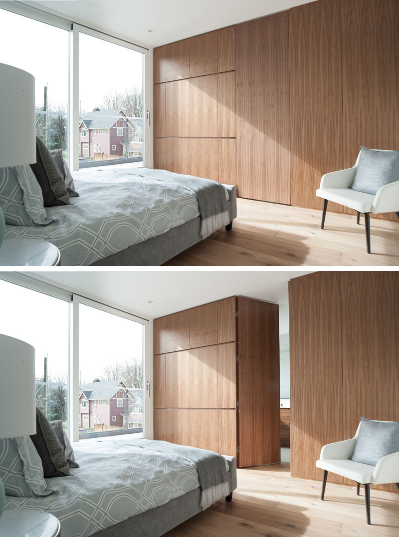 This bedroom features wide plank oak flooring and darker walnut cabinetry. Through a hidden door in the wall of cabinets is an ensuite bathroom.