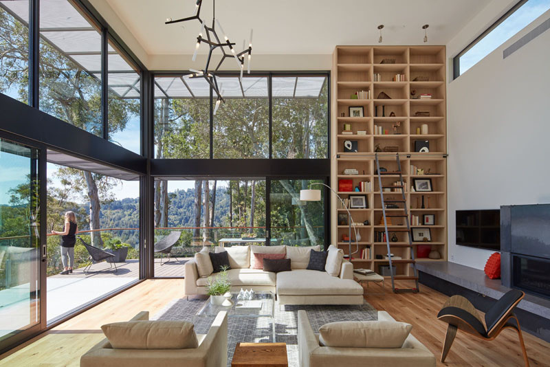 This living room features floor-to-ceiling windows and bookshelf.