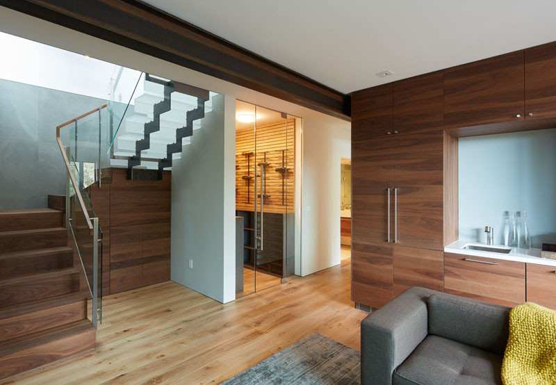 The steel and acrylic stairs transition into wooden stairs, and at the bottom of these stairs is a family room and wine cellar.