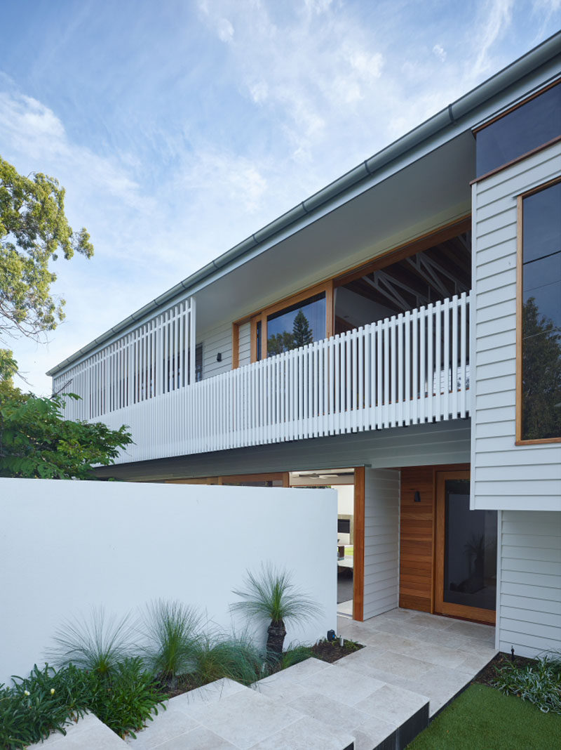 This contemporary home has steps and plants leading you down to the front door.