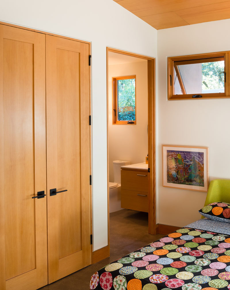 This guest bedroom has an ensuite bathroom and wooden wardrobe for when friends stay over.