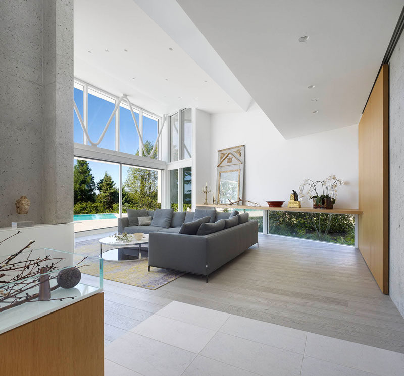 This living room, with double-height ceilings, opens up to the deck and swimming pool. Small windows located at the bottom of the wall, run along the length of the room