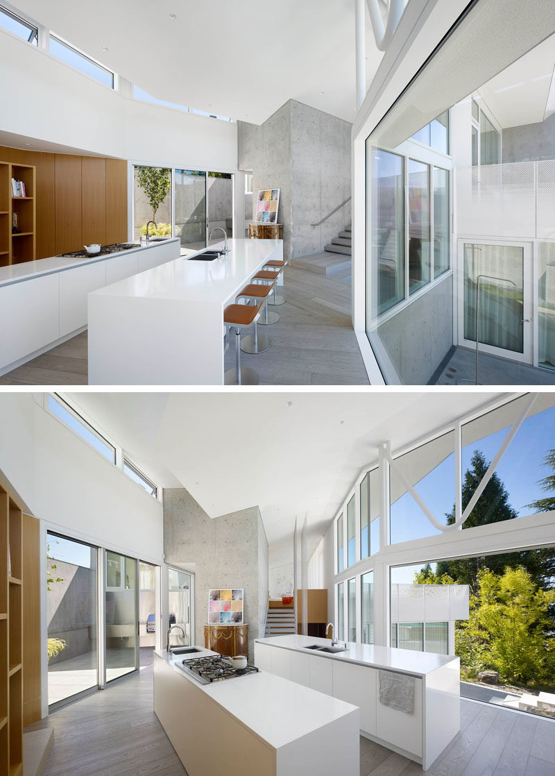 This kitchen is made up of two white islands, one with a stove top and prep sink, and the other with a larger sink, and space for seating.