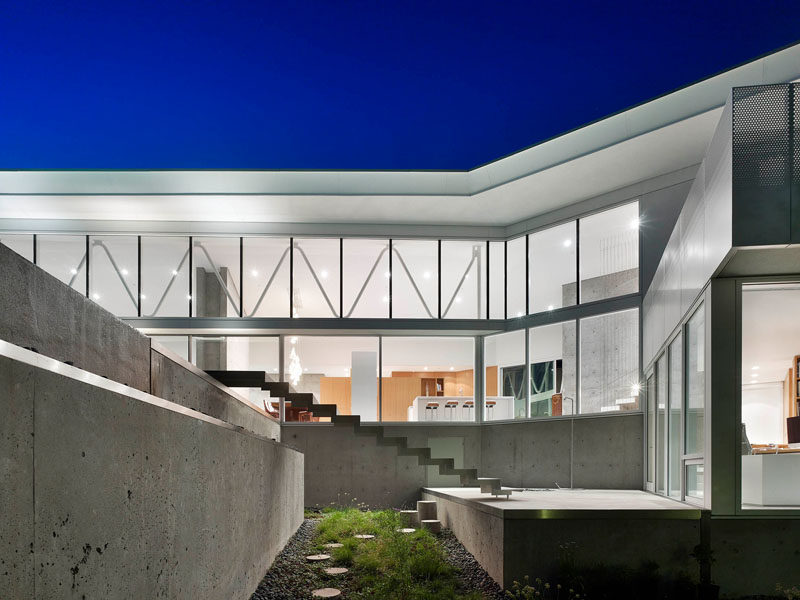 Exterior concrete stairs connect the different levels of the home, with a small garden and path located underneath.