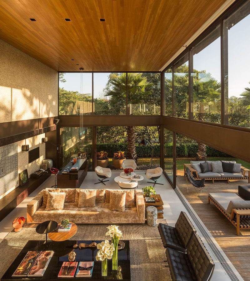 This living room with a double-height ceiling, opens up to the outside deck and swimming pool.