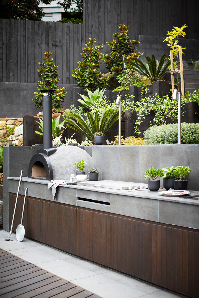 This outdoor kitchen that features hand polished stone and a pizza oven.