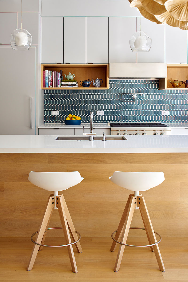 Blue tiles add some color to this white and wood kitchen palette.