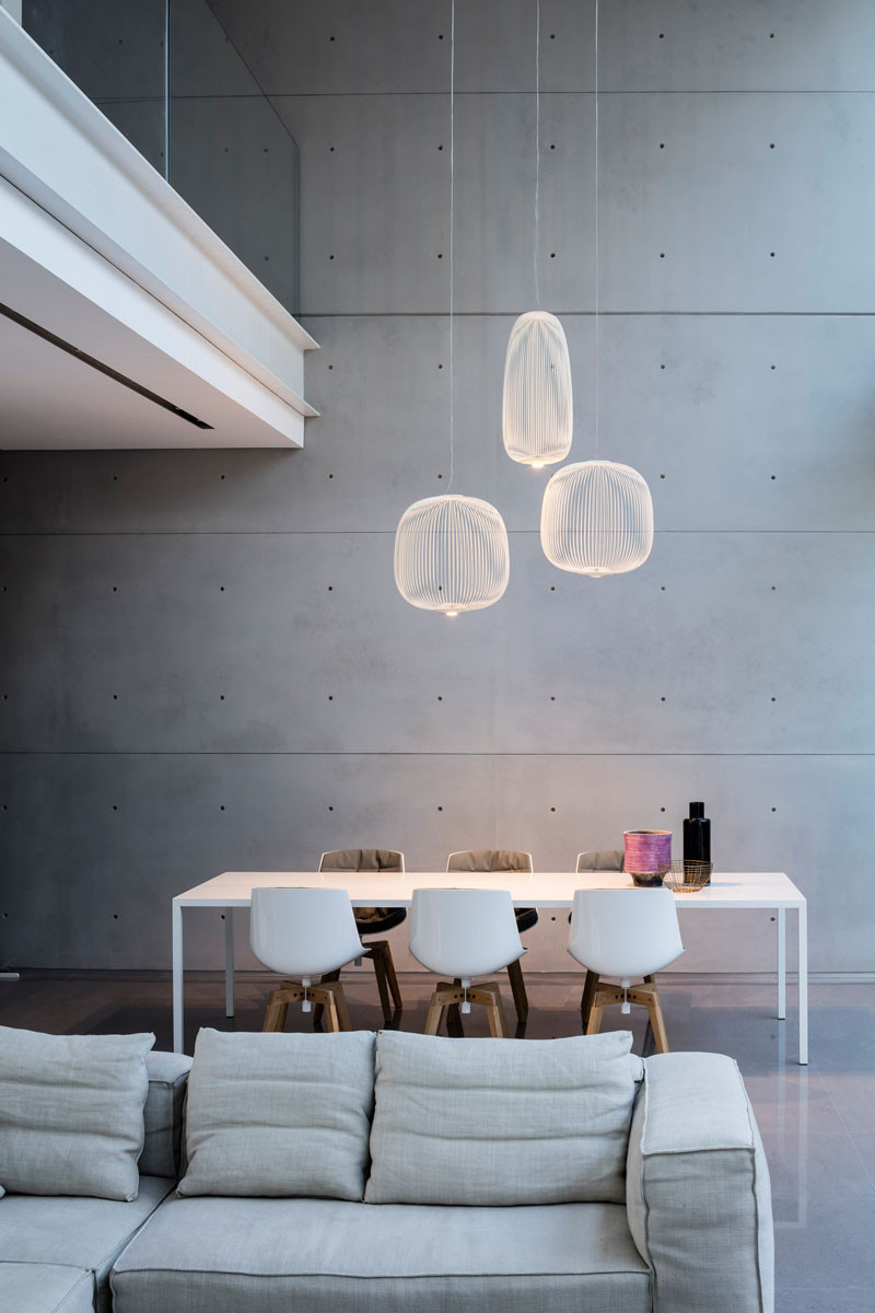 This dining area has three pendant lights that define the location of the table and chairs in this home with an open floor plan.