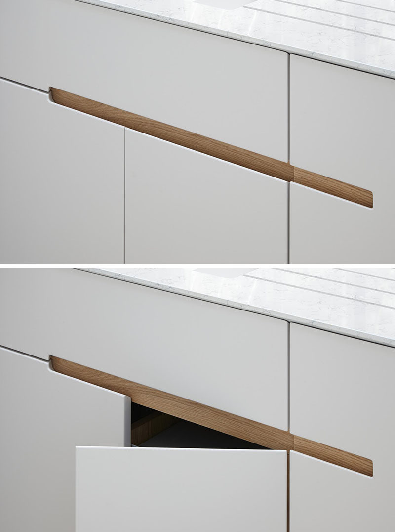 No Hardware For The Kitchen Cabinets In This London Home // This kitchen has white melamine cabinets with a recessed finger detail made from European oak, to make it easy to open the drawers and cabinets.