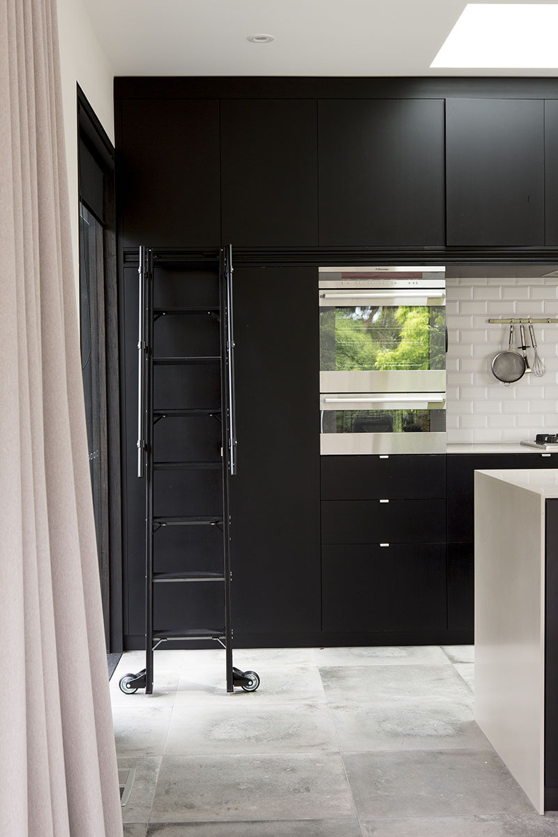 This Matte Black Kitchen Has A Rolling Ladder To Reach The Upper Cabinets