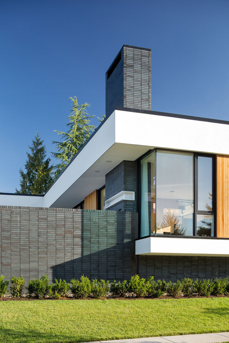 Dark brick contrasts with the white stucco and wood panels.