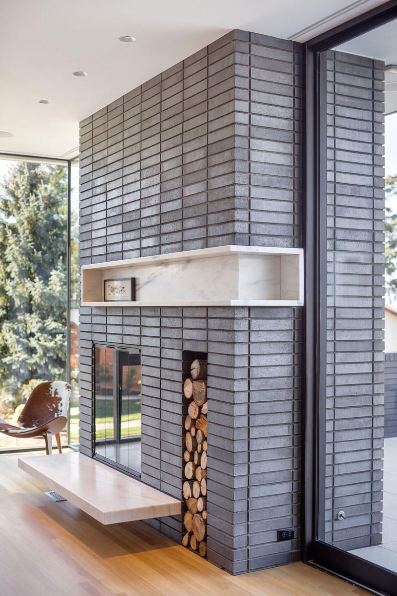 This a large grey brick fireplace can be enjoyed from the inside of the home, as well as from the outdoor patio area too.