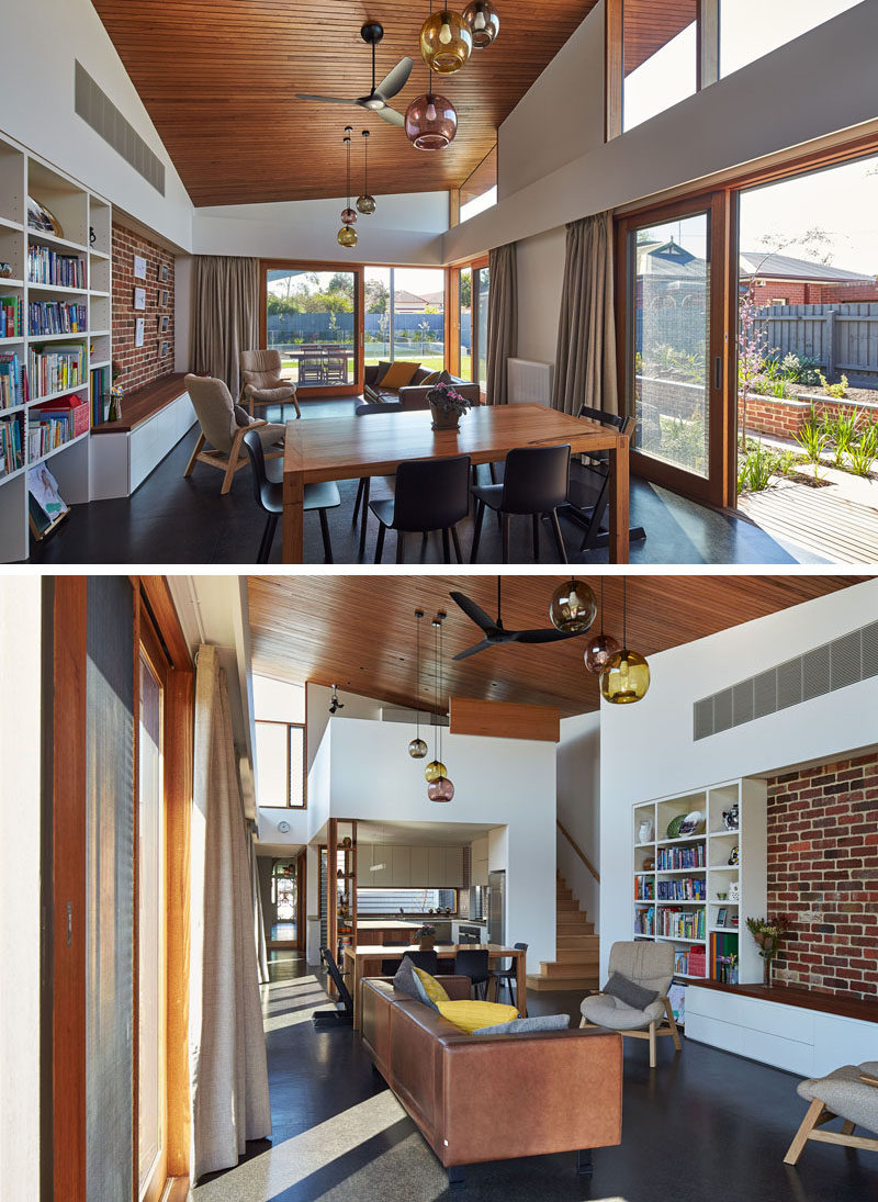 In this contemporary house extension, the dining area and living area share the space, with large sliding wood and glass doors opening up to the outside.