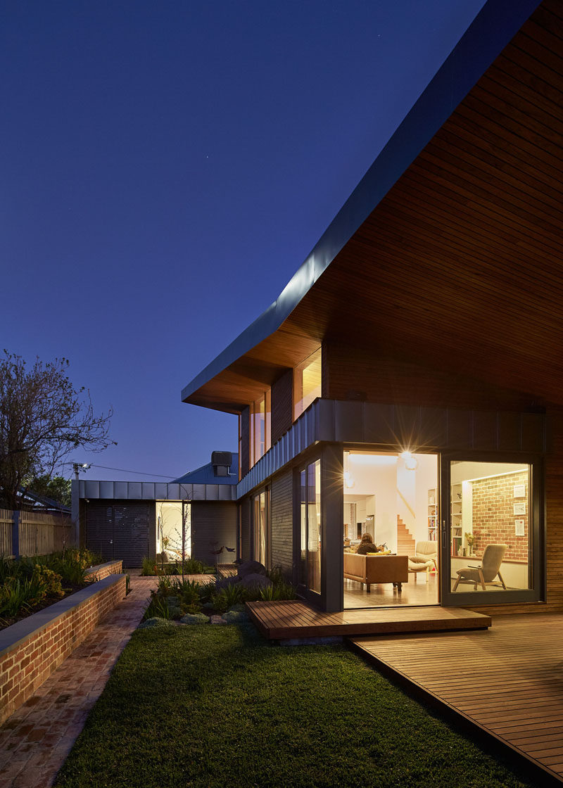 At night, the lights from the inside of this home light up the garden.