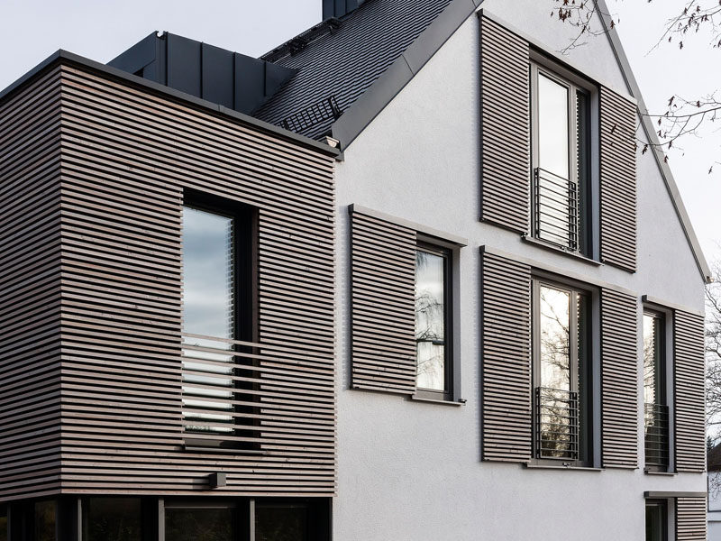 This house has modern window shutters that match the wooden siding used on the house.