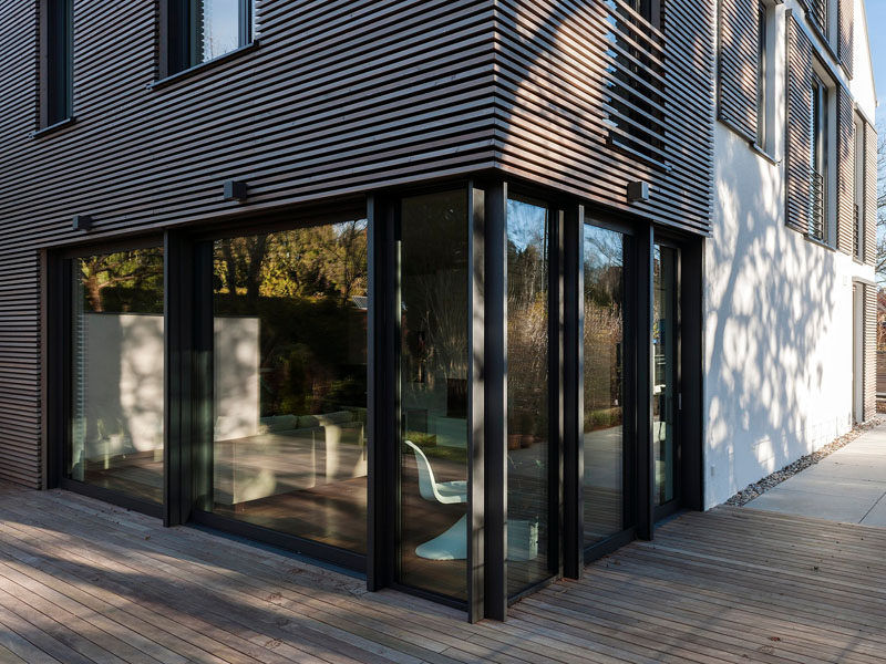 This house has modern window shutters that match the wooden siding used on the house.