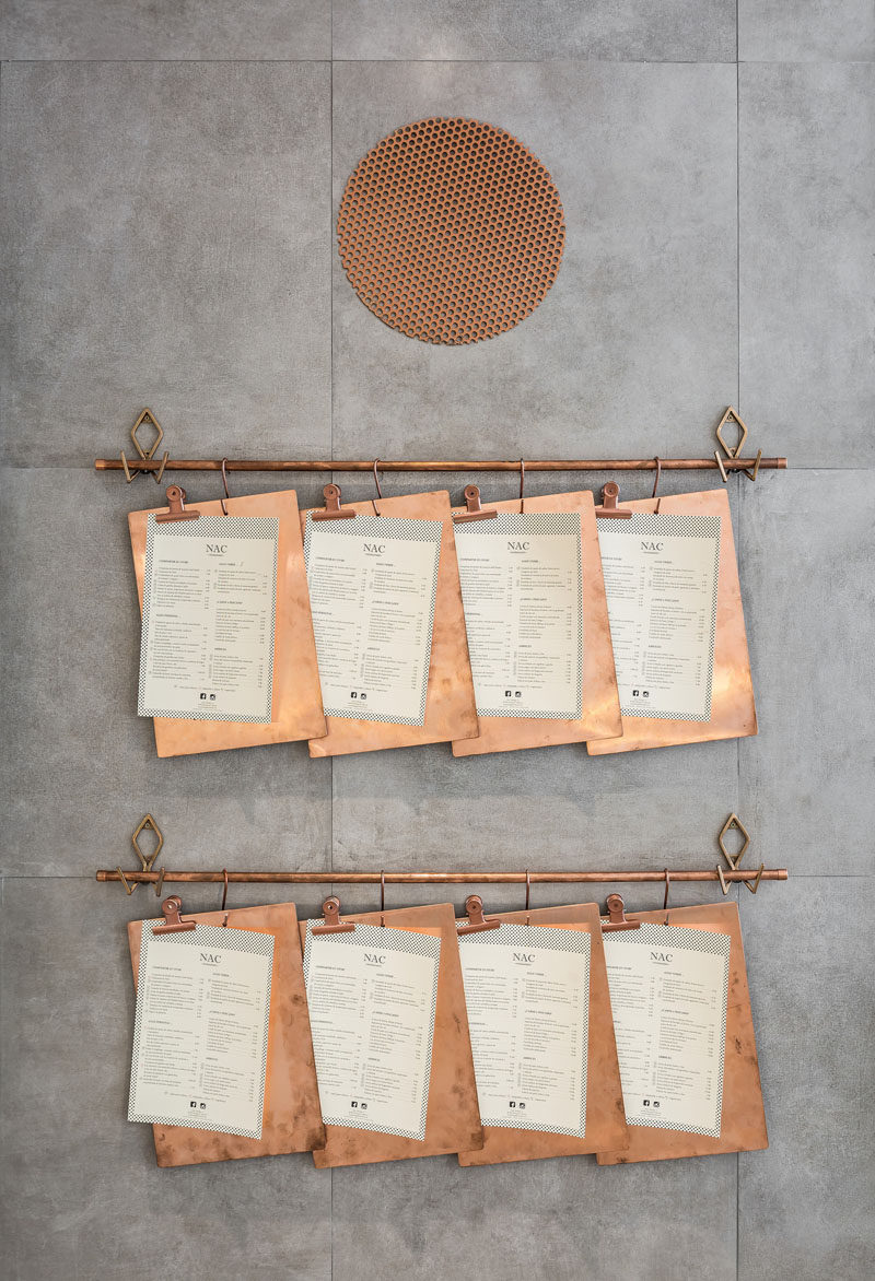 These menus on copper clipboards are hung on a copper pipe attached to the wall.