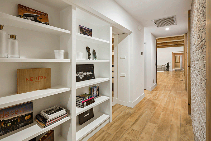 A secret door in this built-in white bookcase in the hallway leads to a hidden bedroom.