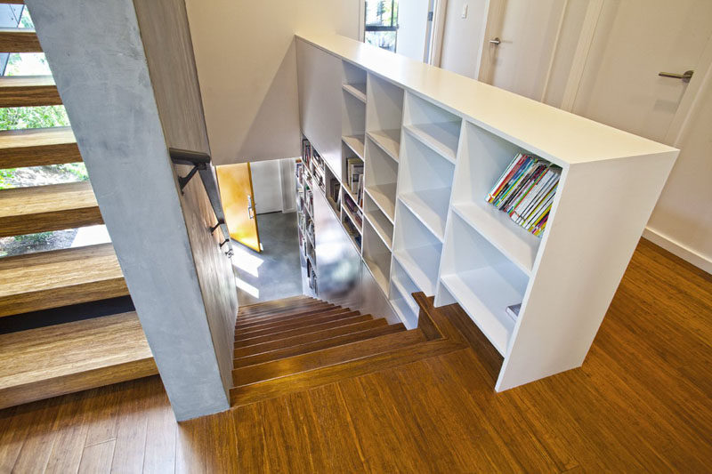 9 Stylish Staircases With Bookshelves As Safety Rails // This Seattle home has a bookshelf running straight up the stairs between the floors.