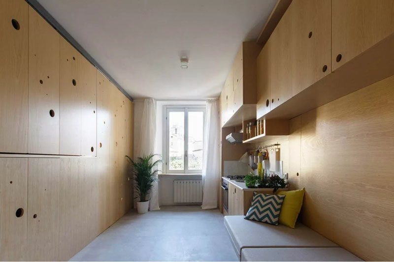 The lounge and kitchen run along one wall in this tiny apartment, with the opposite wall hiding the bedroom and dining room.