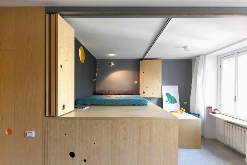This wooden wall opens up to reveal a lofted bed, a dining room and another window, adding more light to the apartment.