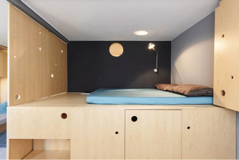 This lofted bed makes it possible to add extra storage to the apartment, but with this design, they are able to lift it up to reveal a wardrobe underneath.