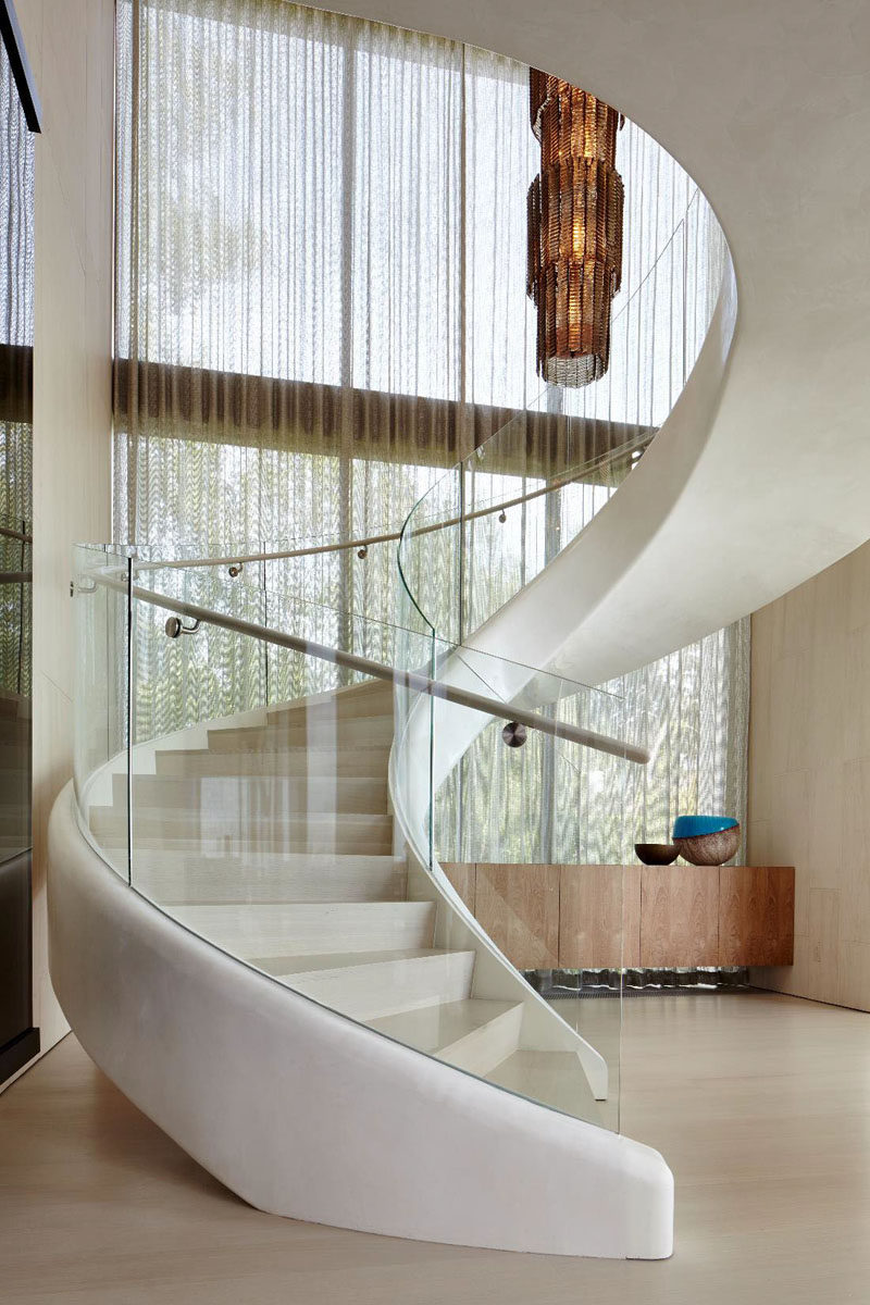 This white sculptural spiral staircase entices you upstairs in this home.