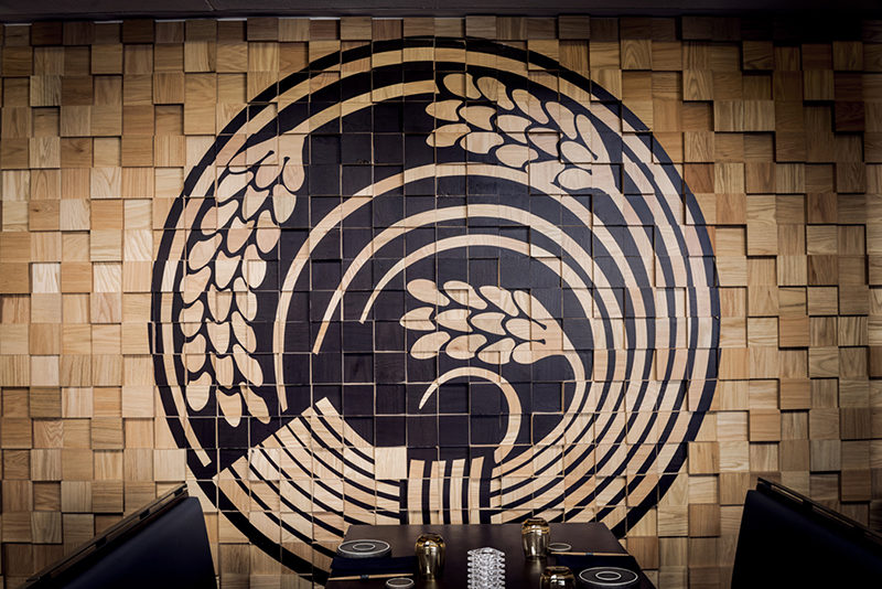 Wall Decor Idea - Murals On Painted Wood Blocks. The wood block wall in this restaurant is filled with Japanese-inspired murals, that have been painted in black.