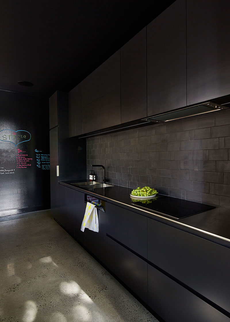 A black backsplash can help create a seamless looking black kitchen. #BlackBacksplash #BlackKitchen #KitchenDesign