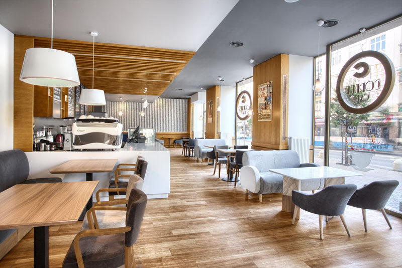 This contemporary cafe in Poland uses a color palette of wood, wood, and grays.