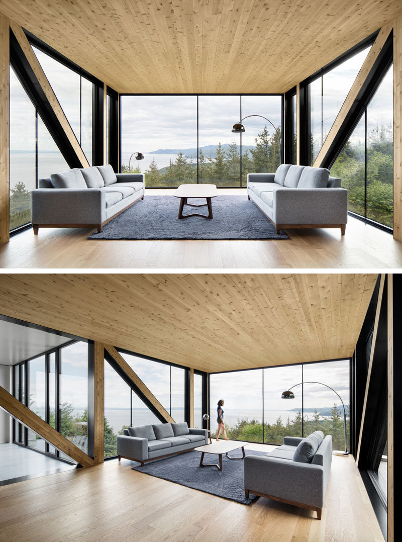 This living room with light wood details, cantilevers out away from the house, providing it with an amazing view from the floor-to-ceiling windows.